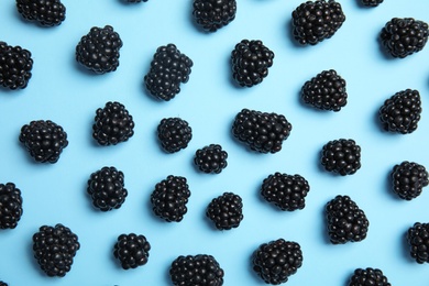 Flat lay composition with ripe blackberries on color background