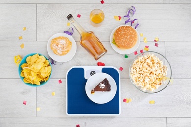 Flat lay composition with scales, different food and alcohol on floor. After party chaos