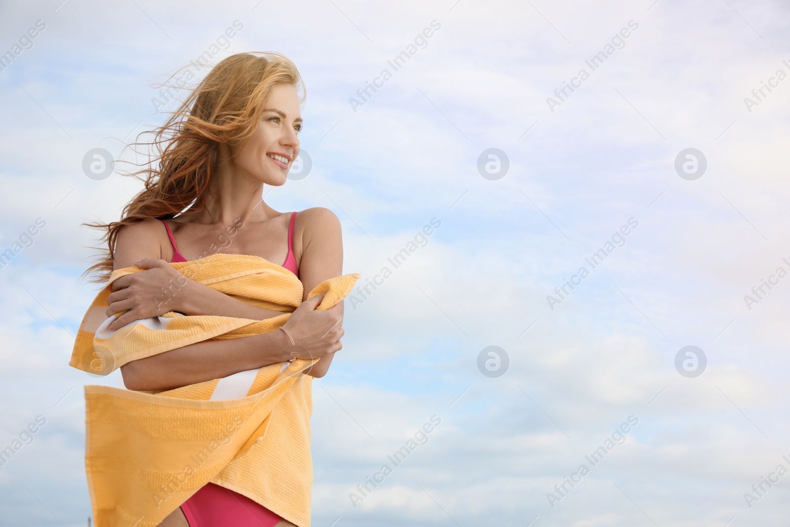 Photo of Beautiful woman with beach towel against sky