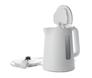 Modern electric kettle with base and plug isolated on white