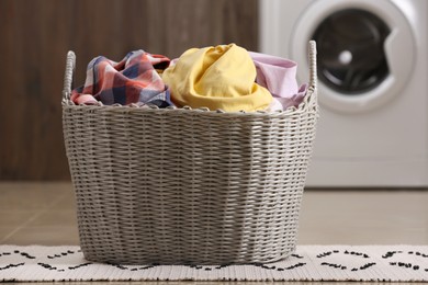 Wicker basket with dirty clothes on floor in laundry room