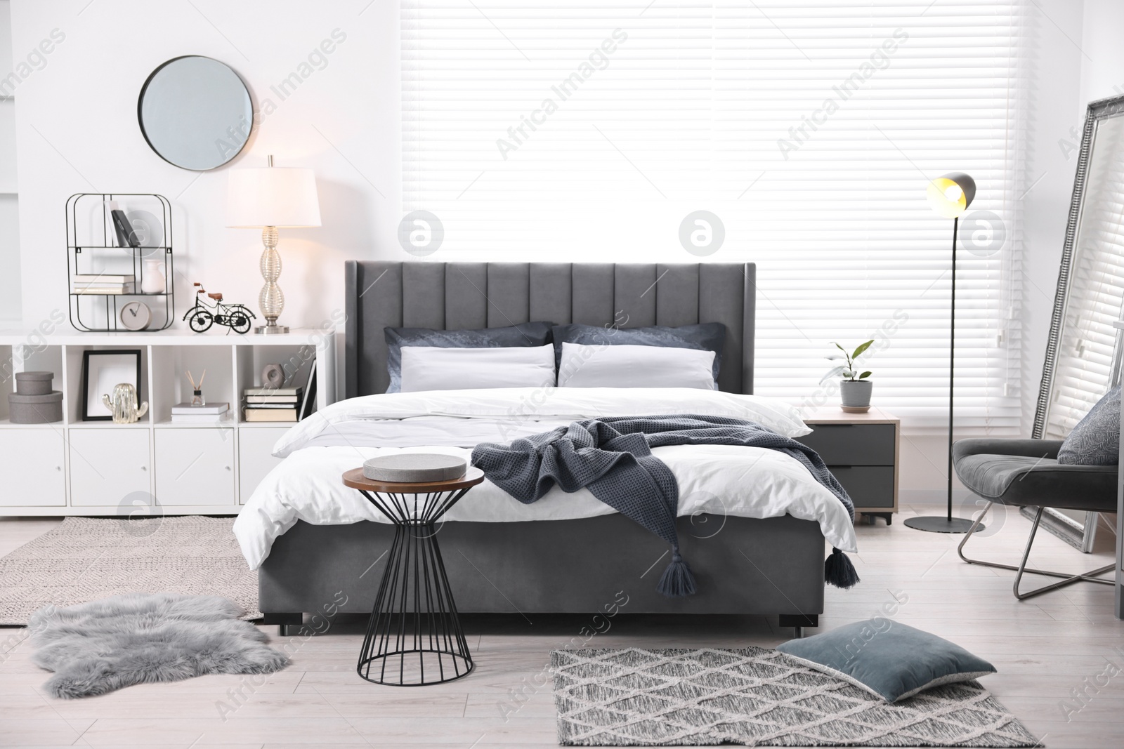 Photo of Bright plaid on bed in stylish bedroom. Interior design