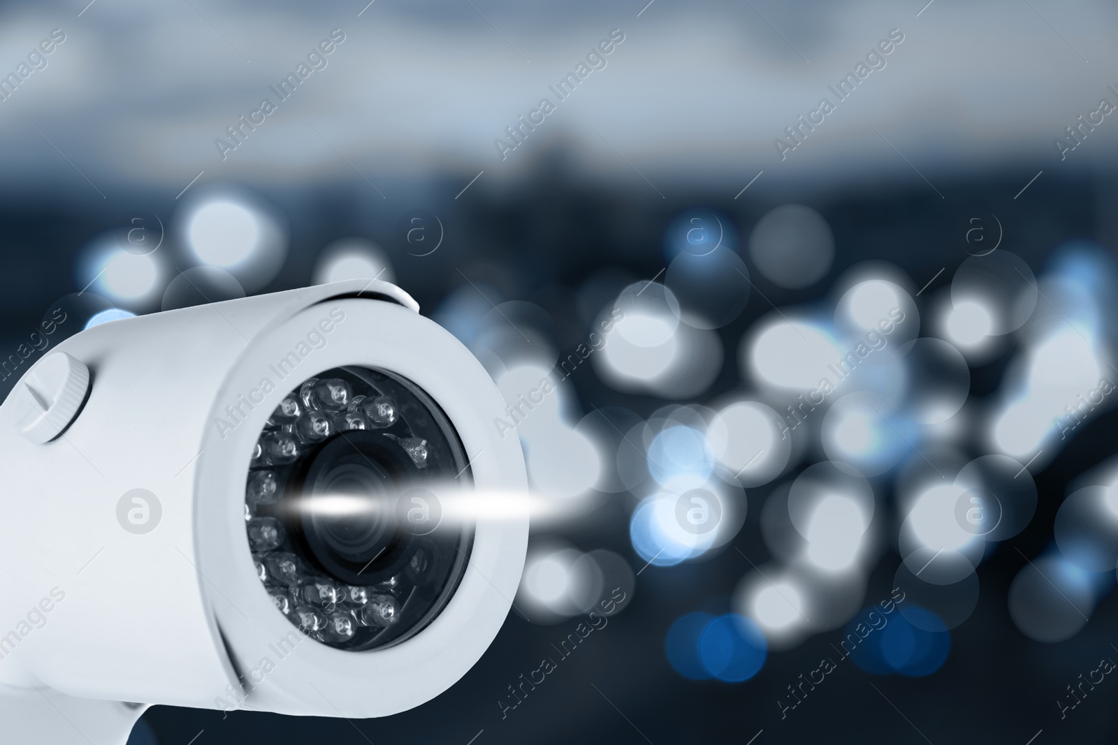 Image of Modern security CCTV camera against blurred background, space for text