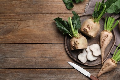 Photo of Whole and cut sugar beets on wooden table, flat lay. Space for text