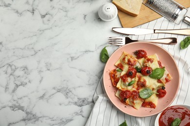 Tasty ravioli with tomato sauce served on white marble table, flat lay. Space for text