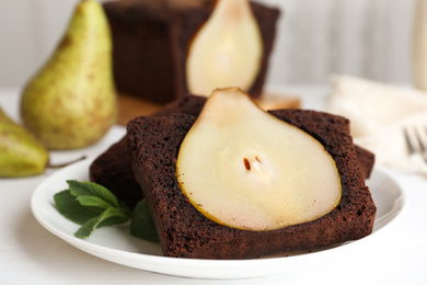 Photo of Tasty pear bread served with mint on white wooden table. Homemade cake