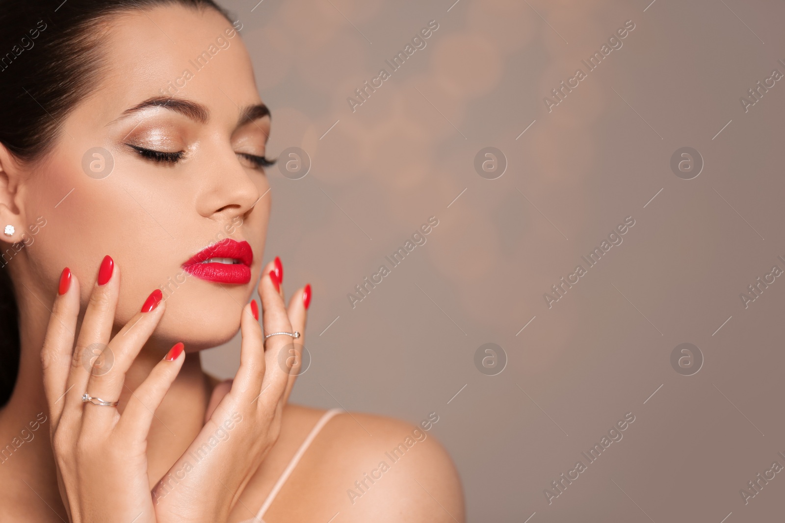Photo of Beautiful young woman with bright manicure on blurred background, space for text. Nail polish trends