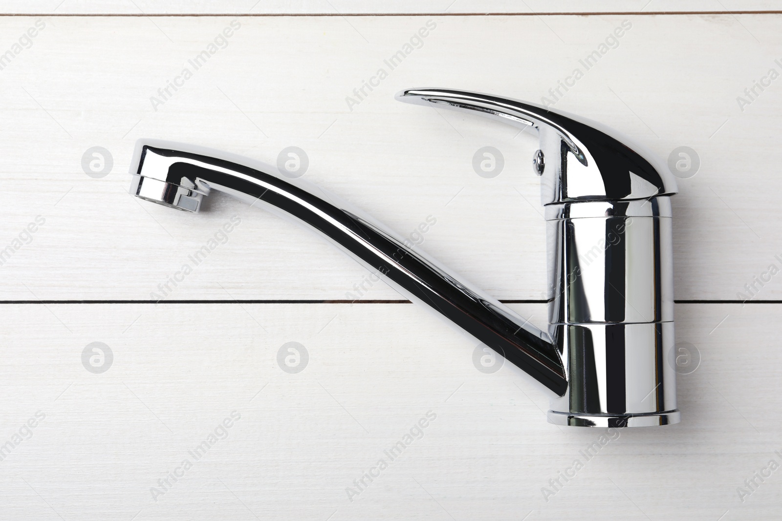 Photo of Single handle water tap on white wooden table, top view