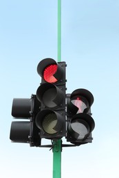 Photo of Traffic lights with red signals against blue sky