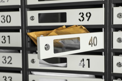 Photo of Open mailbox with keyhole, number and envelopes, closeup