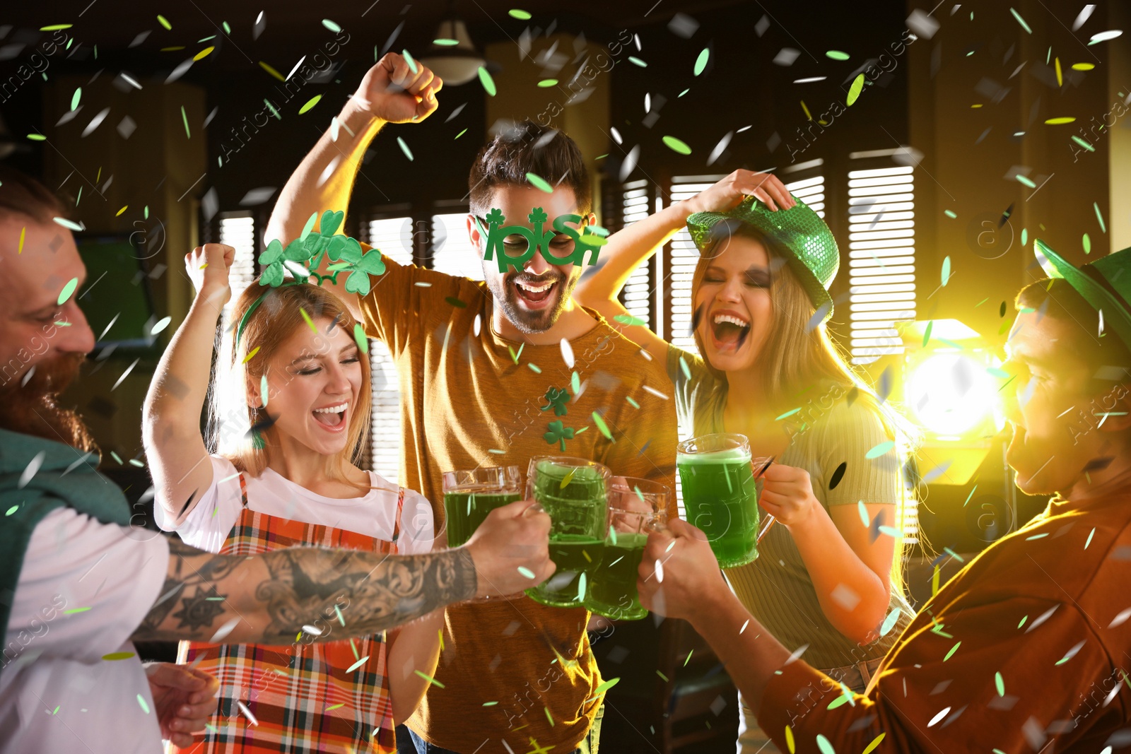 Image of Group of friends toasting with green beer in pub. St. Patrick's Day celebration