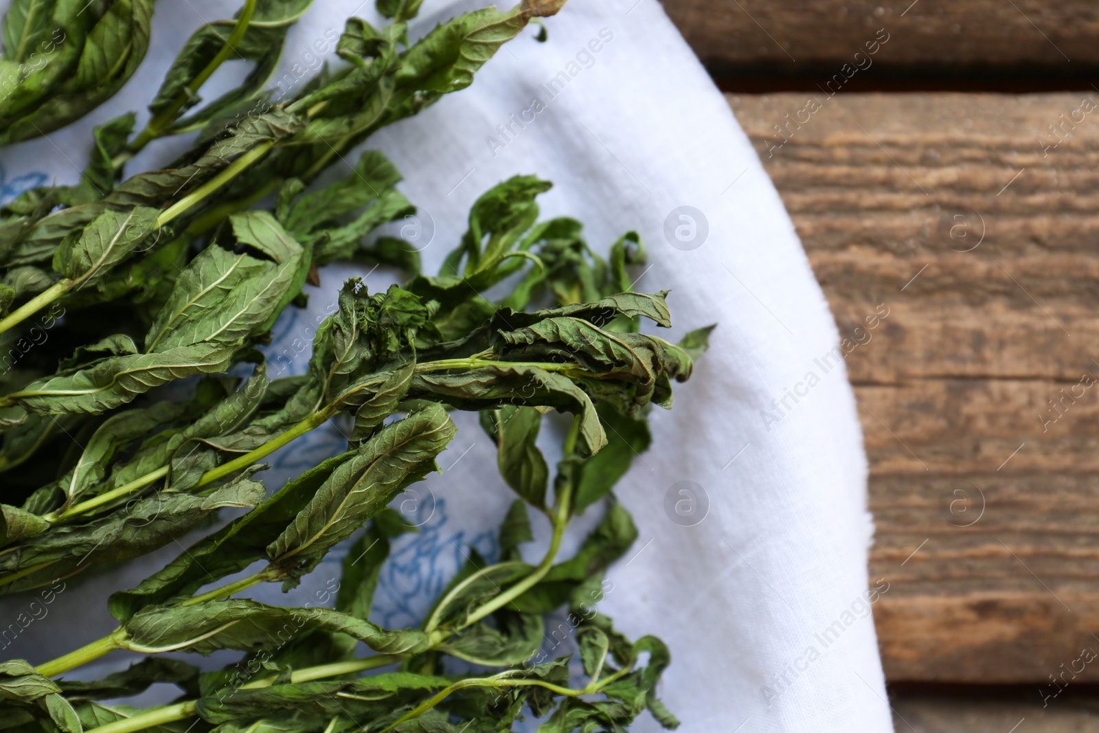 Photo of Bunches of wilted mint on wooden table, top view