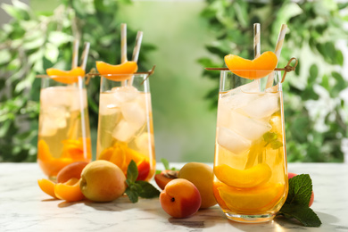Delicious refreshing drink with apricot on white marble table