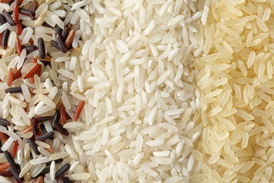 Photo of Brown and other types of rice as background, closeup