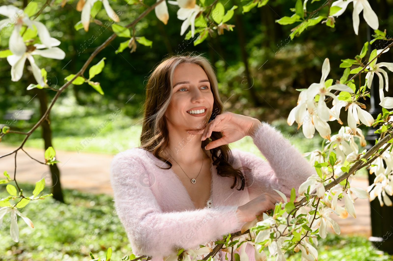 Photo of Beautiful young woman near blossoming tree on spring day