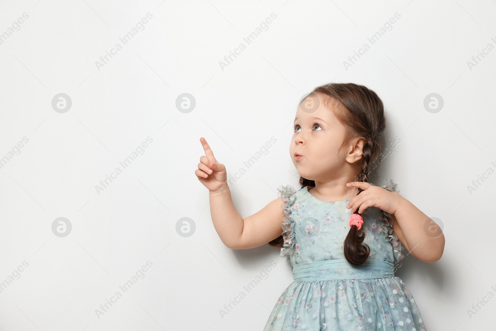 Photo of Cute little girl on light grey background. Space for text