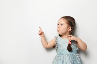 Photo of Cute little girl on light grey background. Space for text