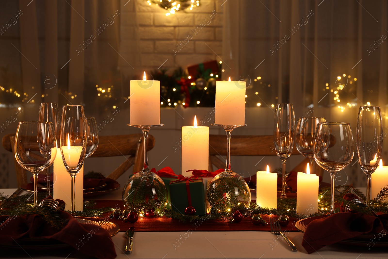 Photo of Christmas table setting with burning candles and festive decor