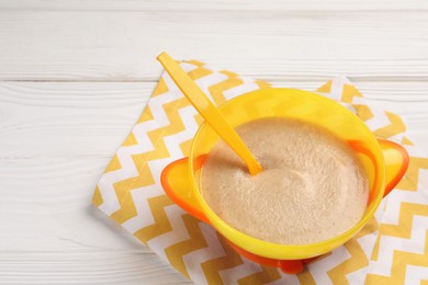 Photo of Baby food. Puree and spoon in bowl on white wooden table. Space for text