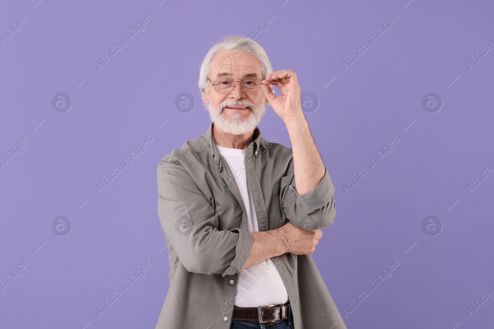 Photo of Portrait of stylish grandpa with glasses on purple background