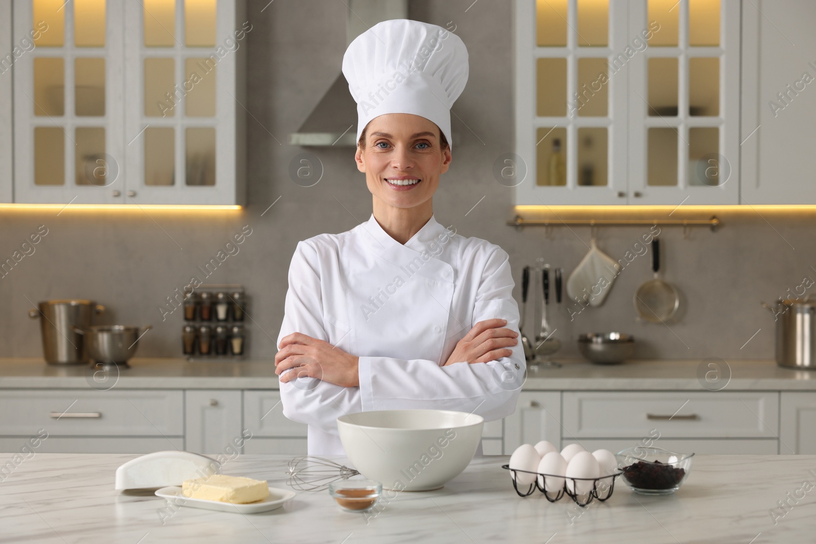 Photo of Portrait of professional chef near table with ingredients in kitchen