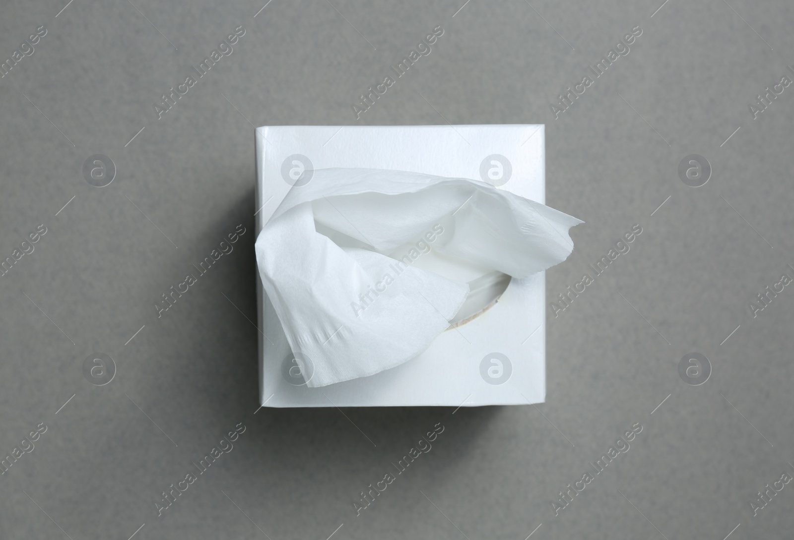 Photo of Box of paper tissues on grey background, top view