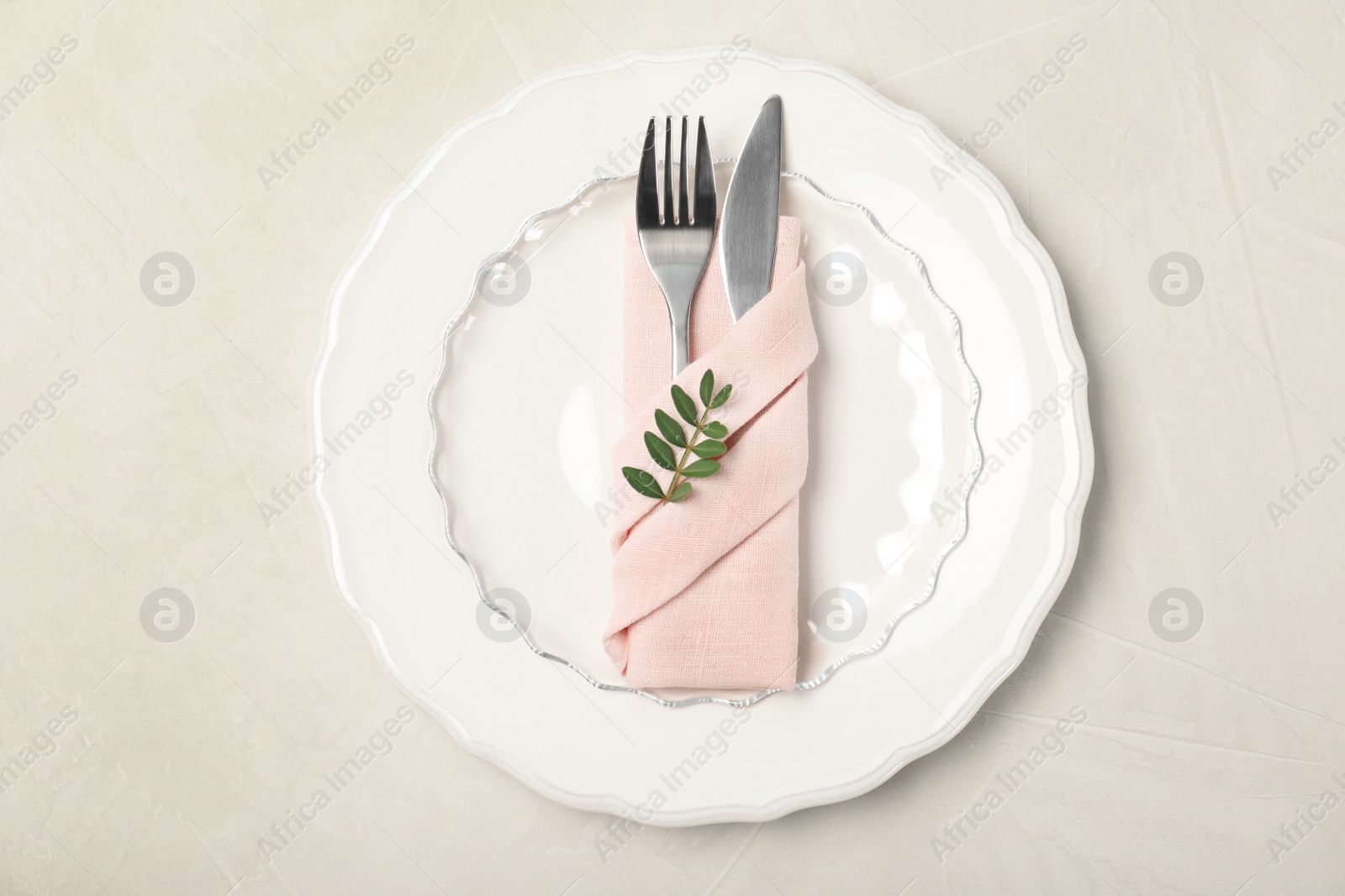 Photo of Plate, cutlery and napkin on light background, top view