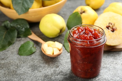 Photo of Delicious quince jam on grey table, closeup