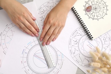 Photo of Astrologer calculating natal chart for making forecast of fate at table, top view. Fortune telling