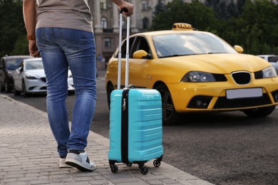 Photo of Man with suitcase near taxi car outdoors, closeup