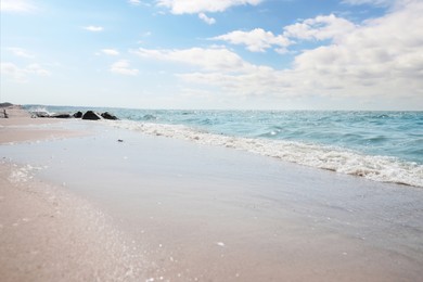 Tropical sandy beach washed by sea on sunny day