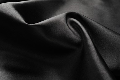 Photo of Crumpled black silk fabric as background, closeup