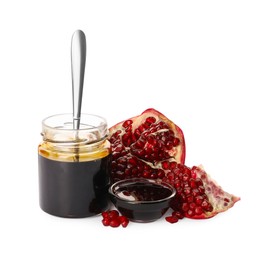 Photo of Fresh ripe fruit, glass jar and bowl of pomegranate sauce on white background