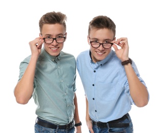 Teenage twin brothers with glasses on white background