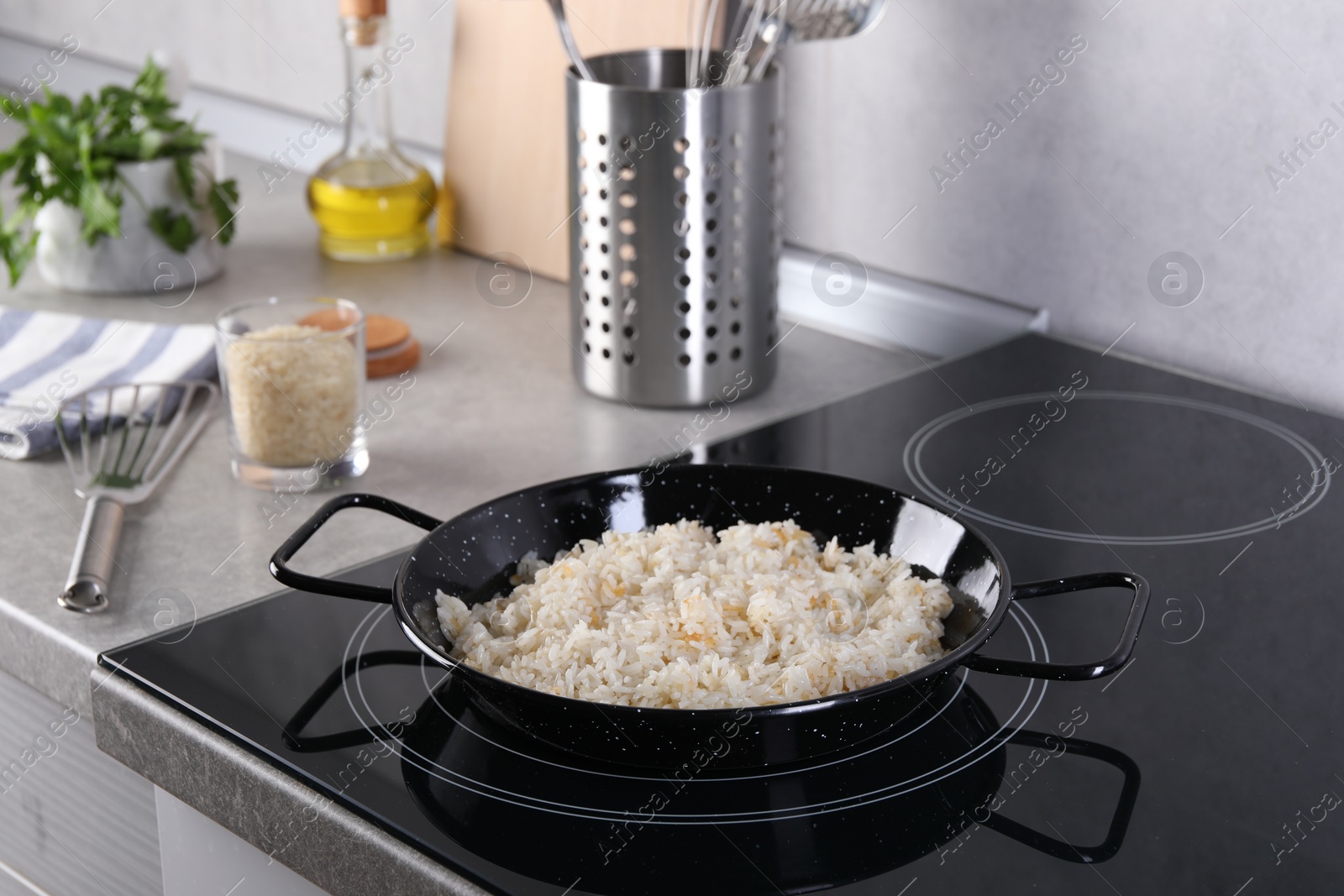 Photo of Cooking tasty rice on induction stove in kitchen