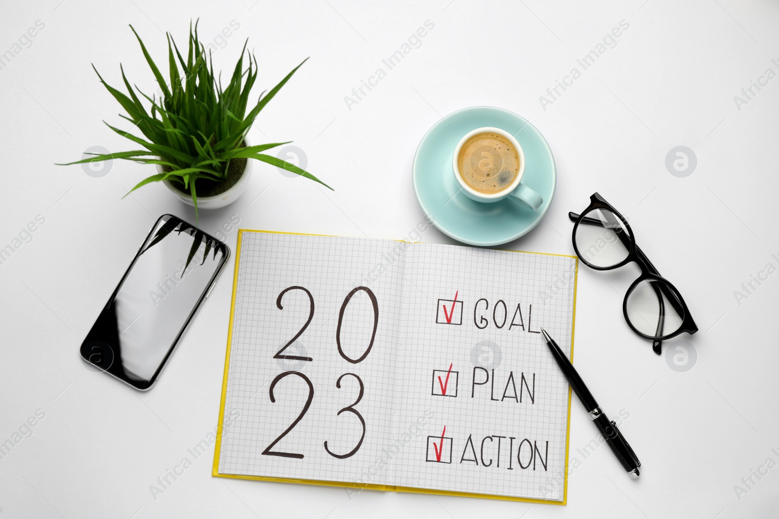 Photo of Flat lay composition of notebook with text 2023 Goal, Plan, Action on white background. New year resolutions