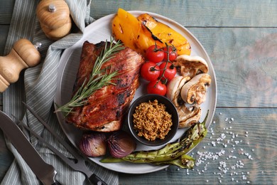 Photo of Delicious grilled meat and vegetables served on wooden table, flat lay