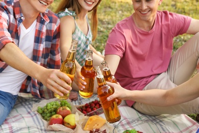 Photo of Young people enjoying picnic in park on summer day, closeup