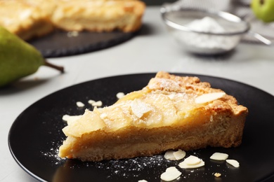 Photo of Piece of delicious sweet pear tart on table, closeup