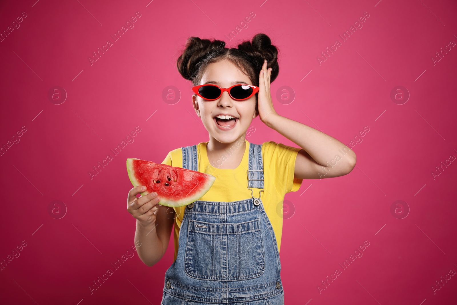 Photo of Cute little girl with watermelon on pink background