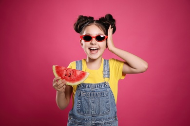 Photo of Cute little girl with watermelon on pink background