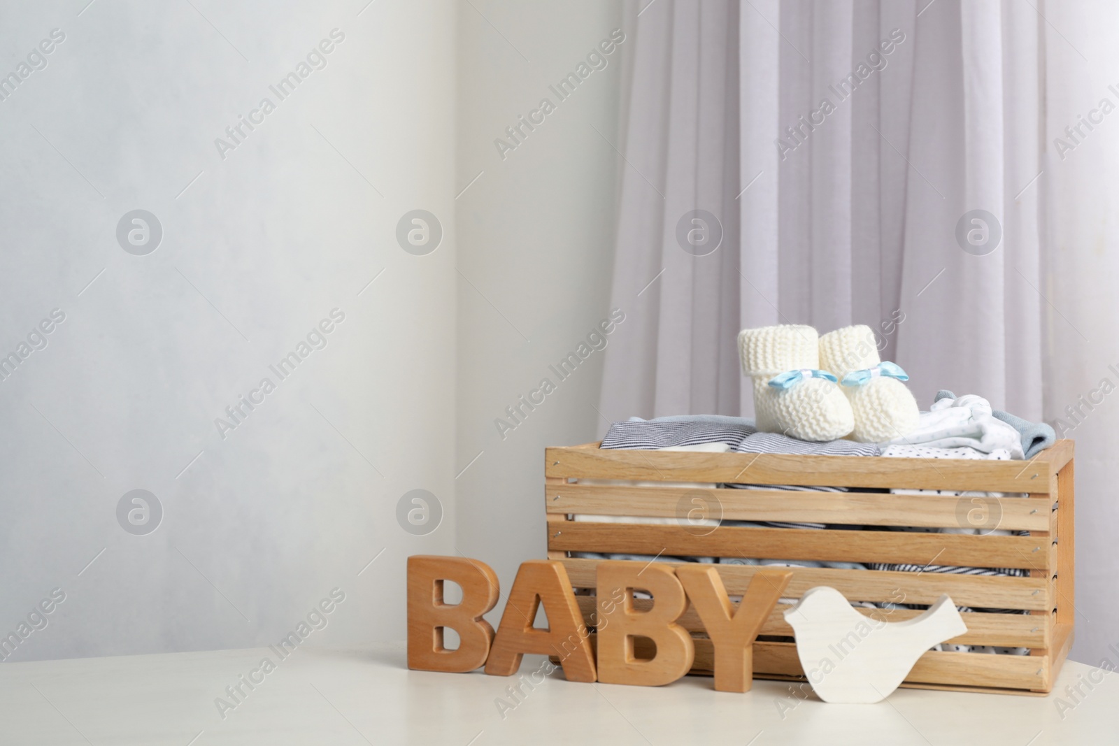 Photo of Composition with child's clothes on white table indoors, space for text