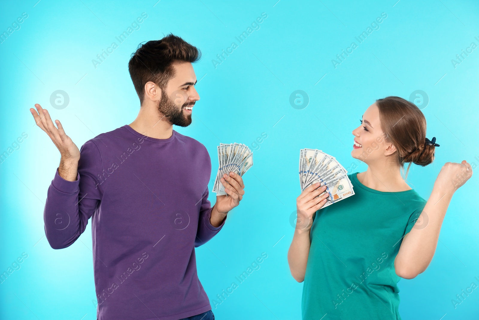 Photo of Happy young couple with money on color background