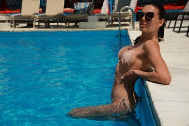 Photo of Beautiful woman wearing bikini in swimming pool. Space for text