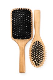 New wooden hair brushes isolated on white, top view