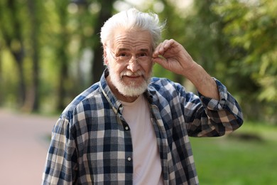 Portrait of happy grandpa with glasses in park