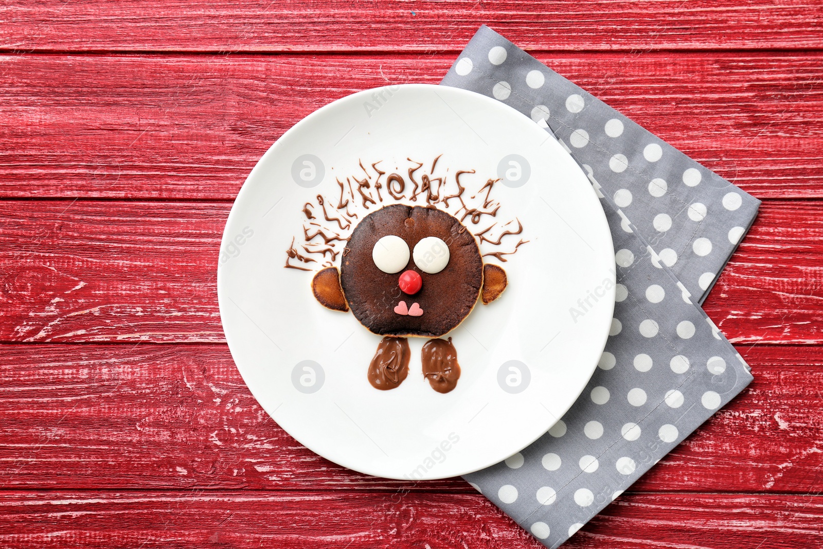 Photo of Flat lay composition with chocolate pancake in form of hedgehog on wooden background. Creative breakfast ideas for kids