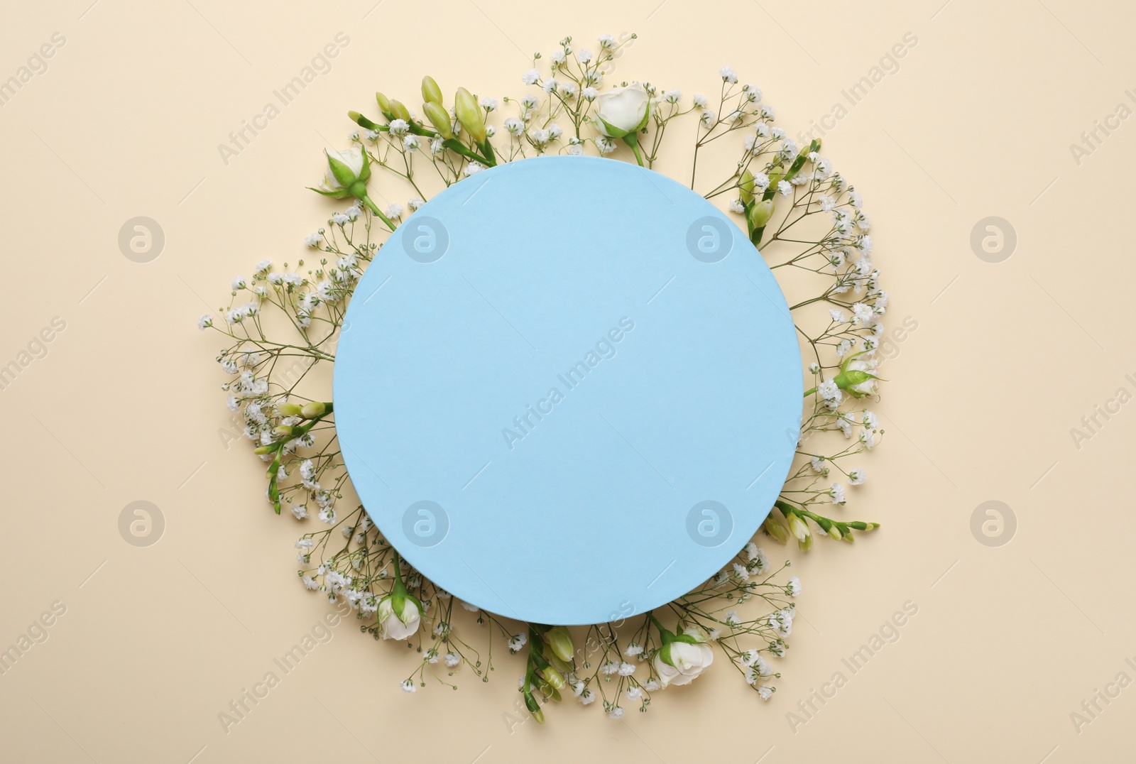 Photo of Blank card with gypsophila, roses and freesia flowers on beige background, top view. Space for text