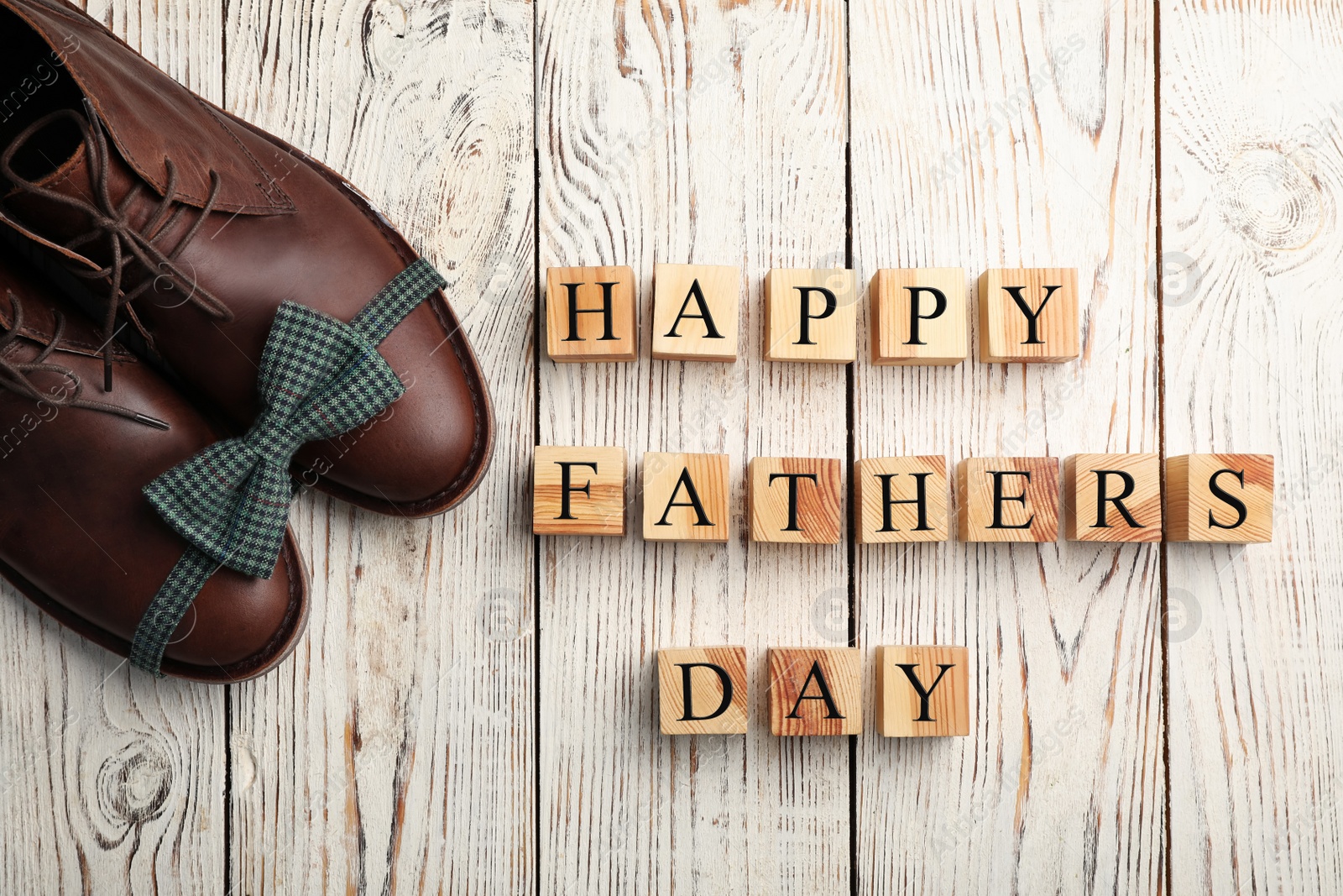 Photo of Shoes, bow tie and cubes on wooden background, top view. Father's day celebration