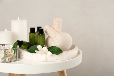 Photo of Composition with beautiful jasmine flowers and skin care products on white table, space for text